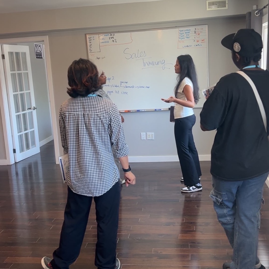 Team members watching a whiteboard briefing before heading to the field.