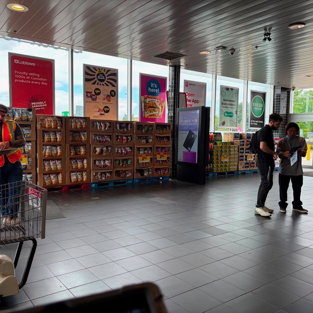 Two Legendz fundraisers speaking with shoppers at a Loblaws storefront.